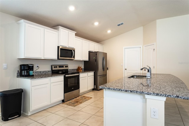 kitchen with sink, appliances with stainless steel finishes, lofted ceiling, and a center island with sink