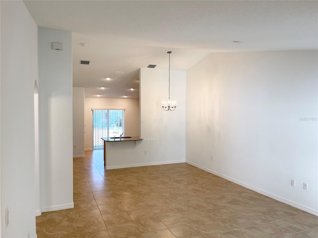 unfurnished room with a notable chandelier and light tile patterned floors