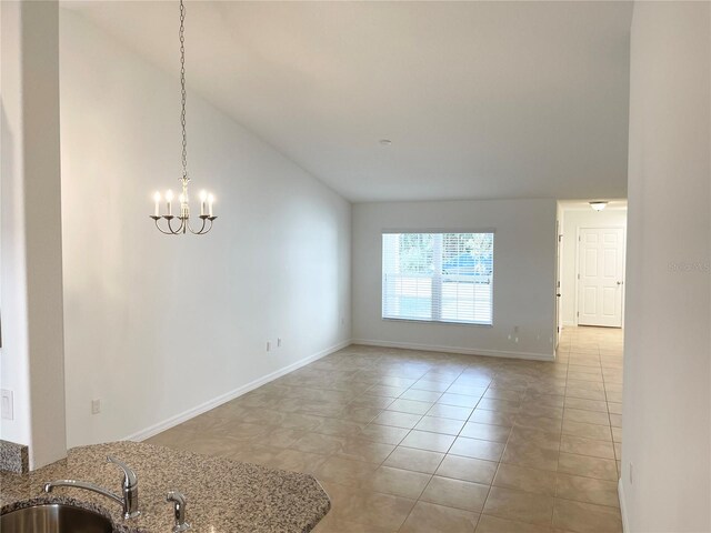 empty room featuring an inviting chandelier, high vaulted ceiling, sink, and light tile patterned floors