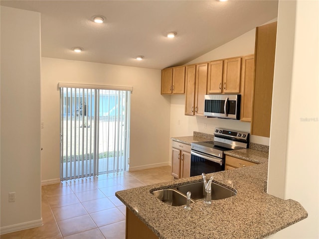 kitchen with light stone counters, sink, light tile patterned floors, appliances with stainless steel finishes, and vaulted ceiling