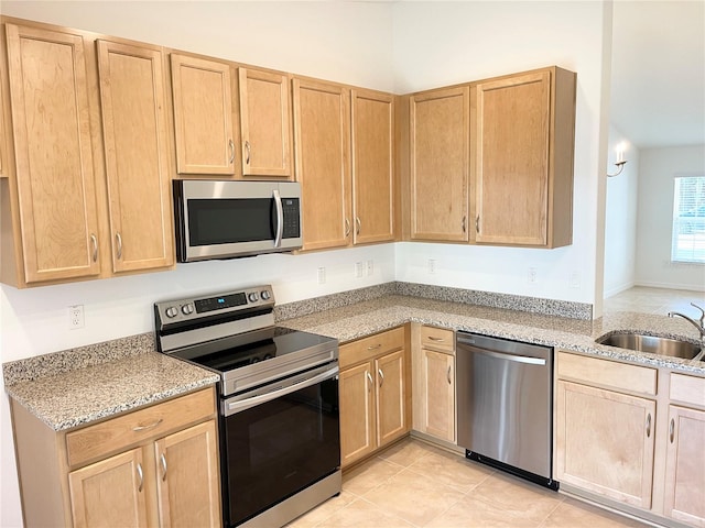 kitchen with light brown cabinetry, sink, and stainless steel appliances