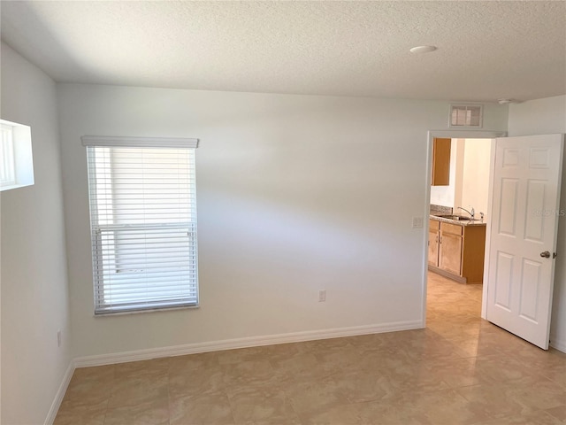 spare room with a textured ceiling and sink