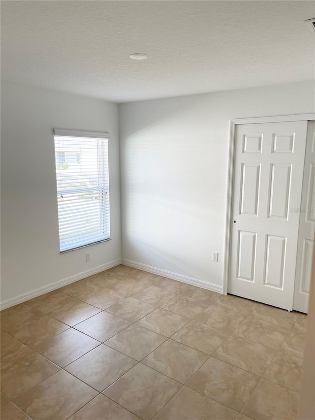 spare room featuring light tile patterned flooring