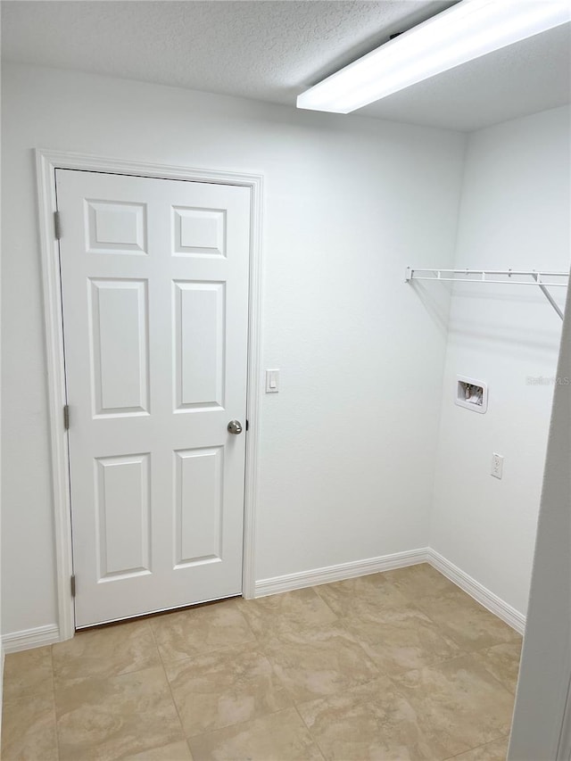 washroom with washer hookup and a textured ceiling