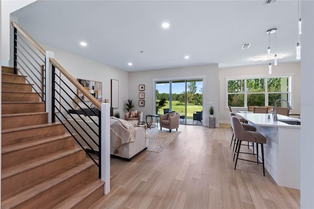 living room with light hardwood / wood-style floors and sink