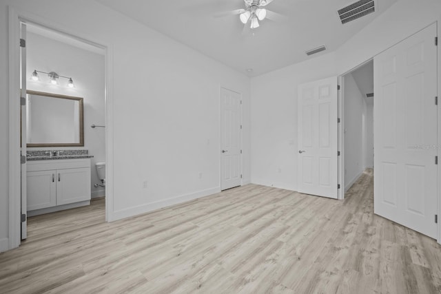 unfurnished bedroom with connected bathroom, light wood-type flooring, sink, and ceiling fan