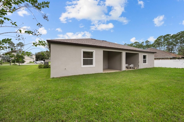 rear view of house featuring a yard and a patio area