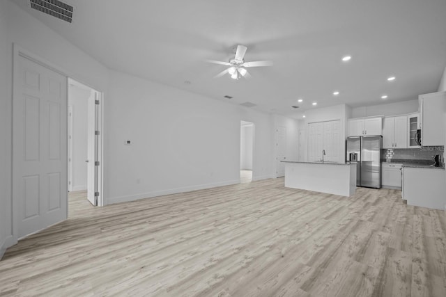 unfurnished living room with sink, ceiling fan, and light hardwood / wood-style flooring