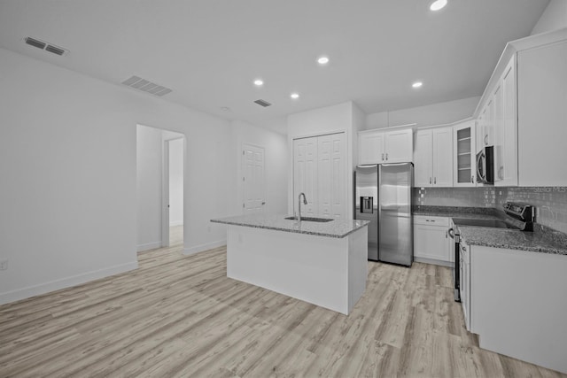 kitchen featuring light hardwood / wood-style floors, stainless steel appliances, a center island with sink, white cabinets, and sink