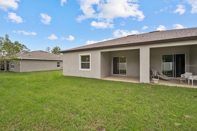 rear view of house with a yard and a patio area