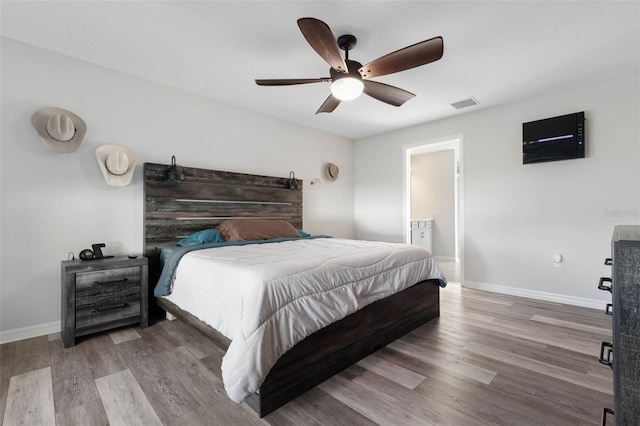 bedroom with hardwood / wood-style flooring, ceiling fan, and ensuite bathroom