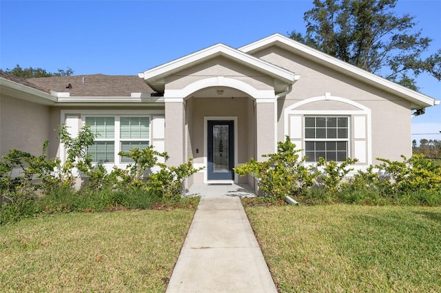 property entrance with a lawn