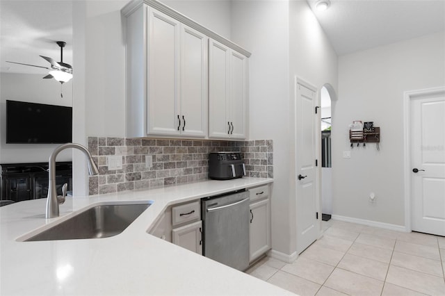 kitchen with dishwasher, white cabinets, sink, light tile patterned flooring, and backsplash