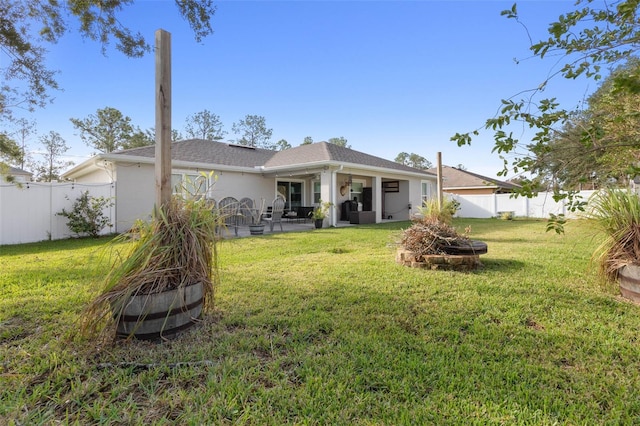 back of house featuring a lawn and a patio