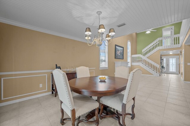 53 Sea Vista Dr, Palm Coast, FL 32137 - dining space featuring a chandelier, light tile patterned floors, baseboards, crown molding, and a wainscoted wall