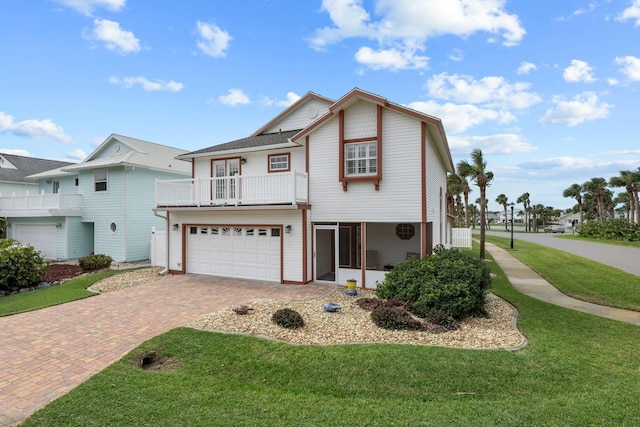 front of property featuring a front yard, a garage, and a balcony