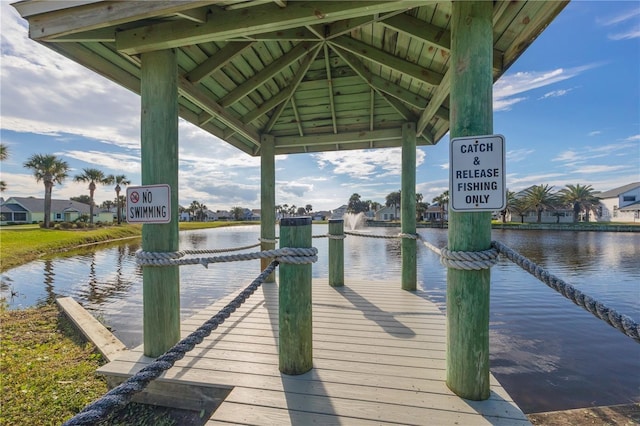 view of dock with a gazebo and a water view