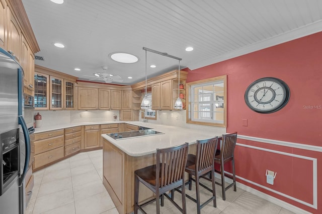 kitchen featuring kitchen peninsula, ceiling fan, pendant lighting, ornamental molding, and a breakfast bar area