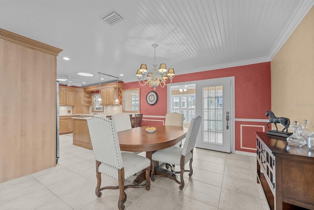 53 Sea Vista Dr, Palm Coast, FL 32137 - dining area featuring a chandelier, crown molding, light tile patterned floors, a wainscoted wall, and a ceiling fan