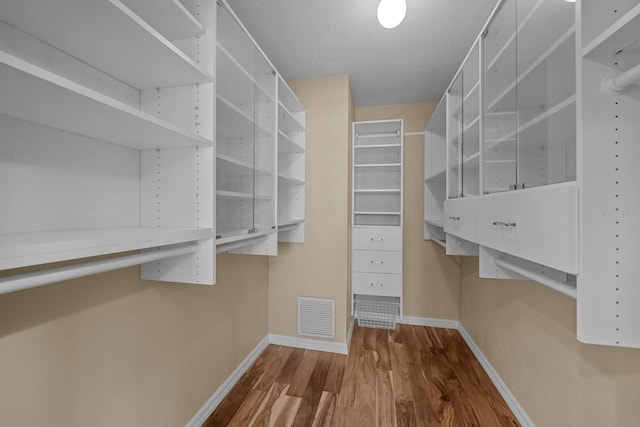 walk in closet with hardwood / wood-style flooring