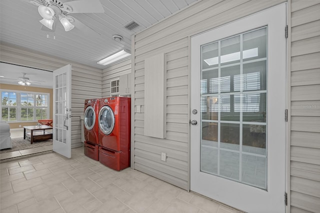 laundry area with wood walls, separate washer and dryer, and ceiling fan