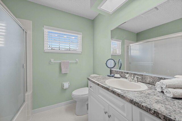 53 Sea Vista Dr, Palm Coast, FL 32137 - full bath with plenty of natural light, vanity, baseboards, toilet, and a textured ceiling