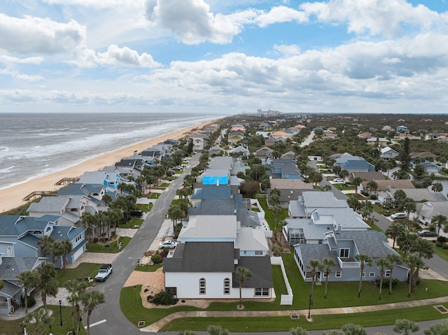 birds eye view of property with a water view and a beach view