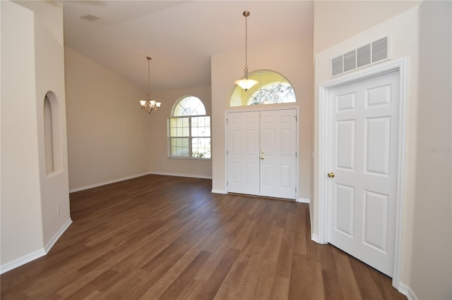 entrance foyer with high vaulted ceiling, dark hardwood / wood-style floors, and an inviting chandelier