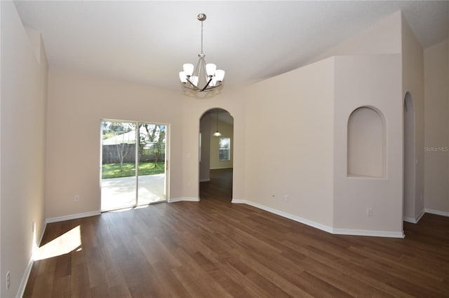 spare room with dark hardwood / wood-style flooring and a chandelier