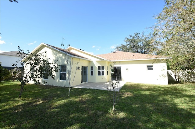 rear view of house featuring a yard and a patio area