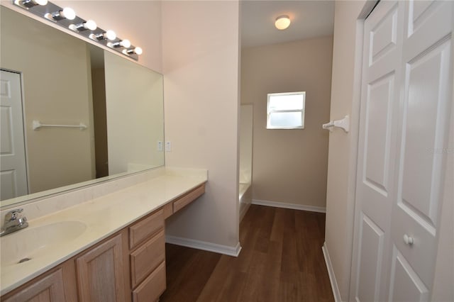 bathroom with vanity, a bathtub, and wood-type flooring