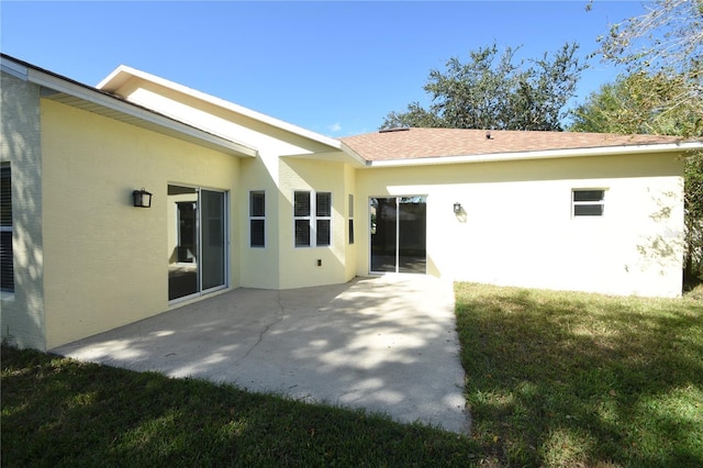 back of property with a patio area and a lawn