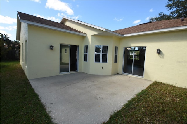 rear view of property featuring a patio and a lawn