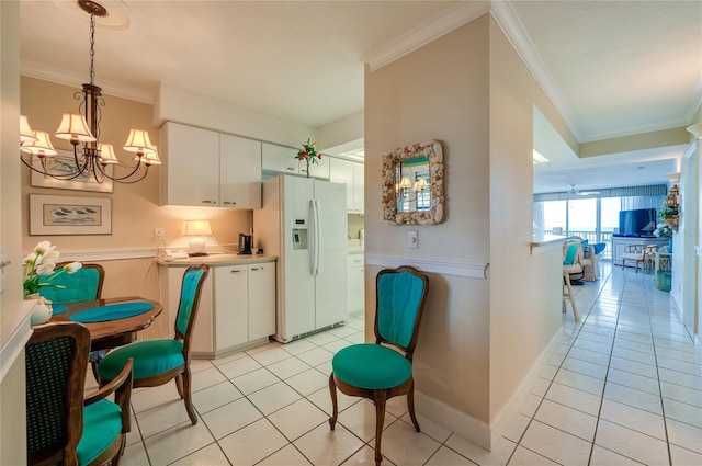 kitchen with white cabinets, ornamental molding, a notable chandelier, decorative light fixtures, and white refrigerator with ice dispenser