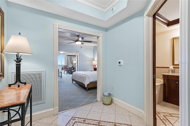 tiled bedroom featuring ensuite bath, ornamental molding, and ceiling fan