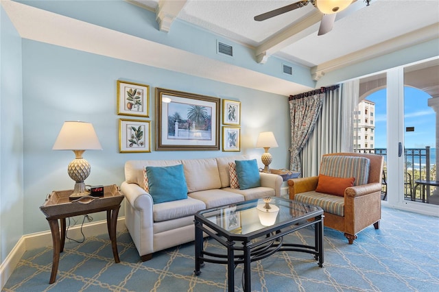 living room with beam ceiling, carpet, and ceiling fan