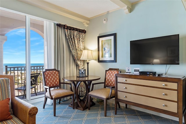 living area with ornamental molding, beamed ceiling, a water view, and carpet floors