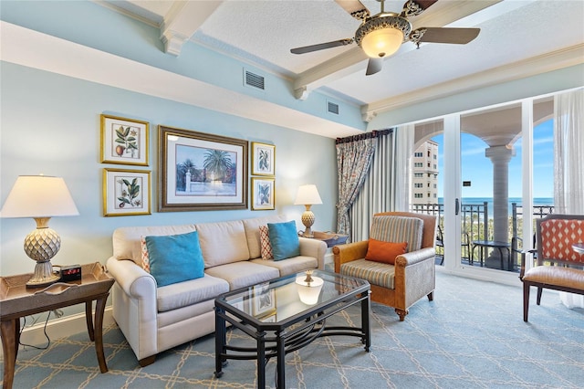 living room featuring beam ceiling, decorative columns, carpet floors, and ceiling fan