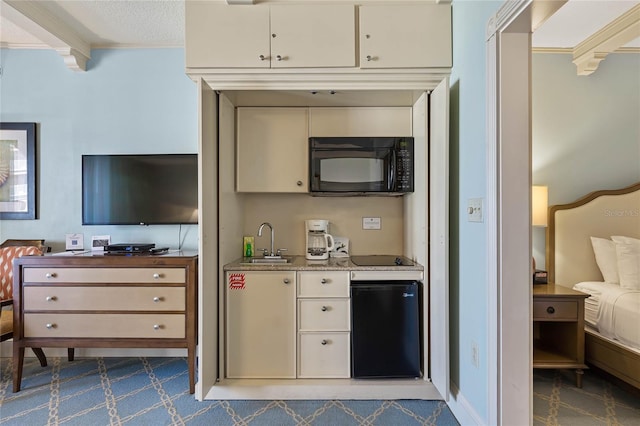 kitchen featuring beam ceiling, light stone countertops, black appliances, dark colored carpet, and sink