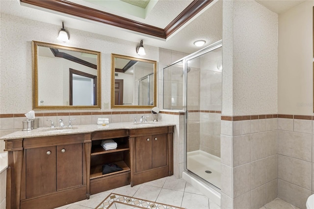 bathroom with a textured ceiling, a shower with shower door, vanity, crown molding, and tile patterned flooring