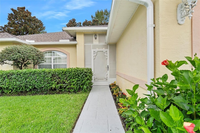 property entrance with a lawn