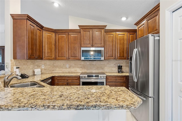 kitchen with sink, tasteful backsplash, vaulted ceiling, and stainless steel appliances