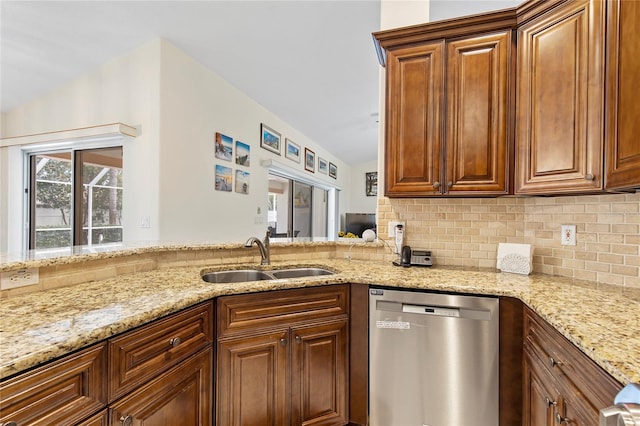 kitchen with dishwasher, light stone countertops, lofted ceiling, and sink