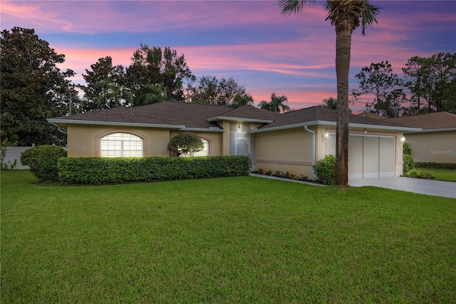 ranch-style house featuring a lawn and a garage