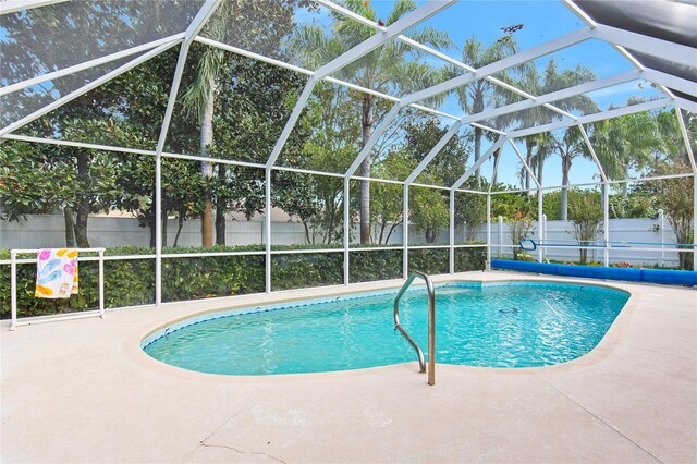 view of swimming pool with glass enclosure and a patio area