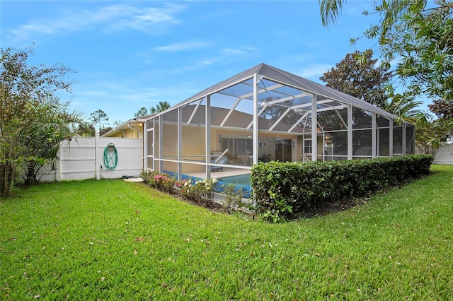 back of property featuring glass enclosure and a lawn