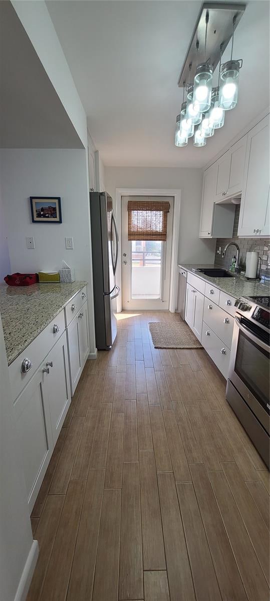 kitchen featuring white cabinetry, light hardwood / wood-style floors, appliances with stainless steel finishes, and sink