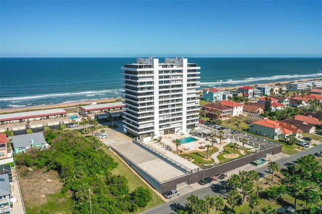 birds eye view of property with a water view and a beach view