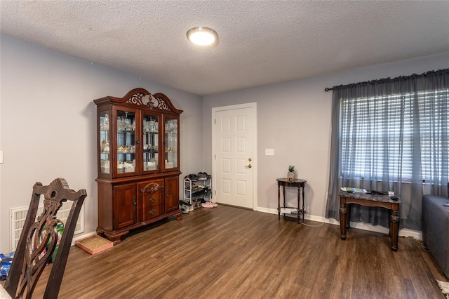 interior space featuring a textured ceiling and dark hardwood / wood-style flooring