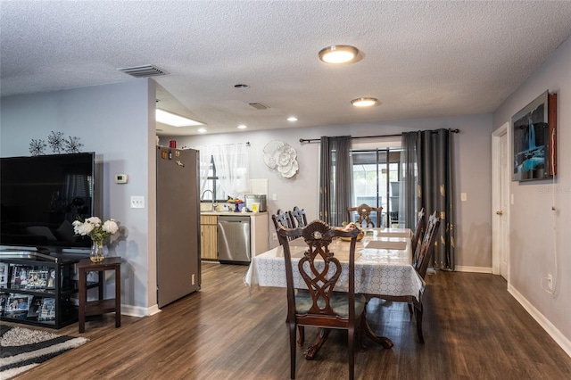 dining space with a textured ceiling and dark wood-type flooring